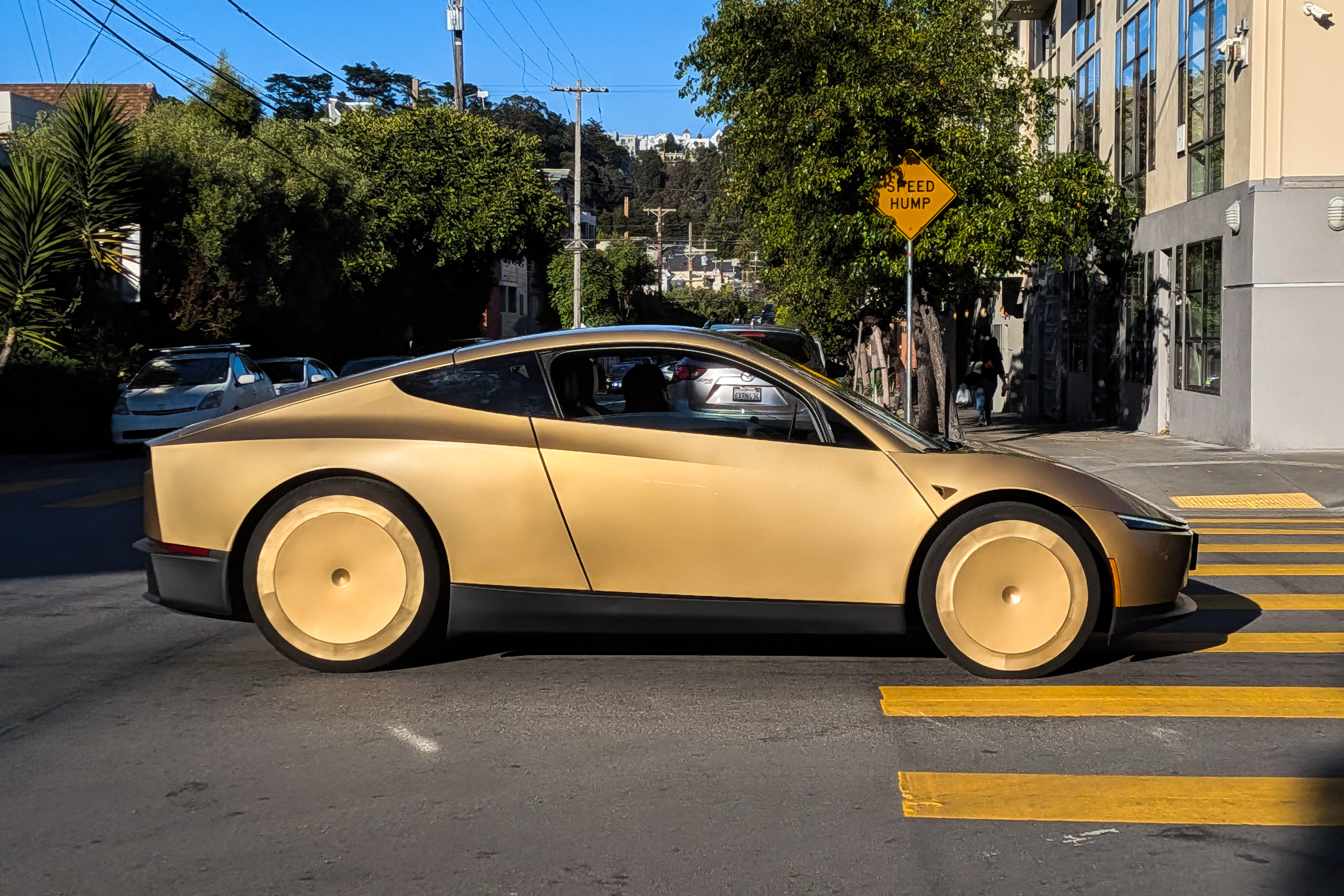 A gold Tesla Cybercab on a San Francisco street.