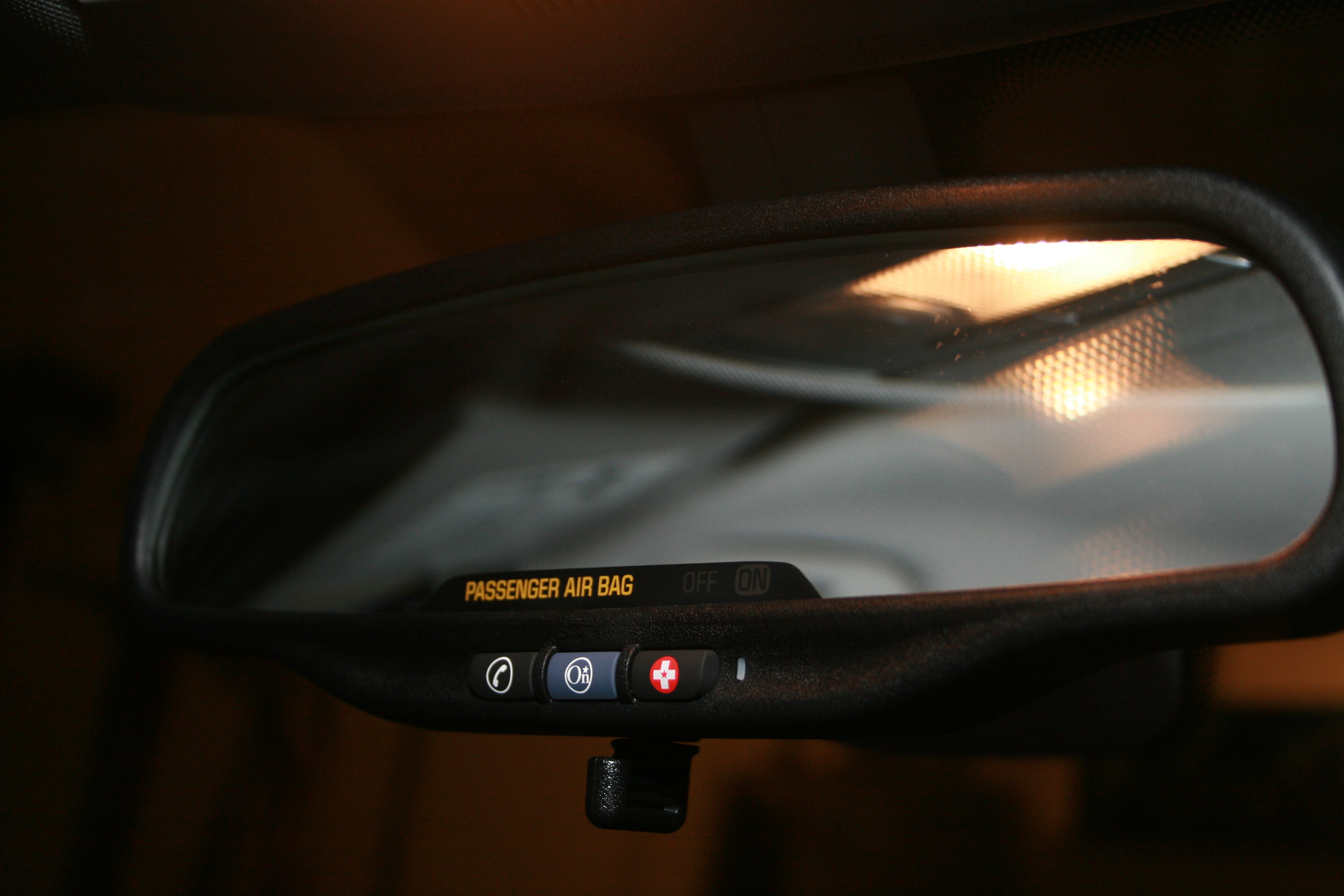 A rear-view mirror with OnStar and emergency buttons.
