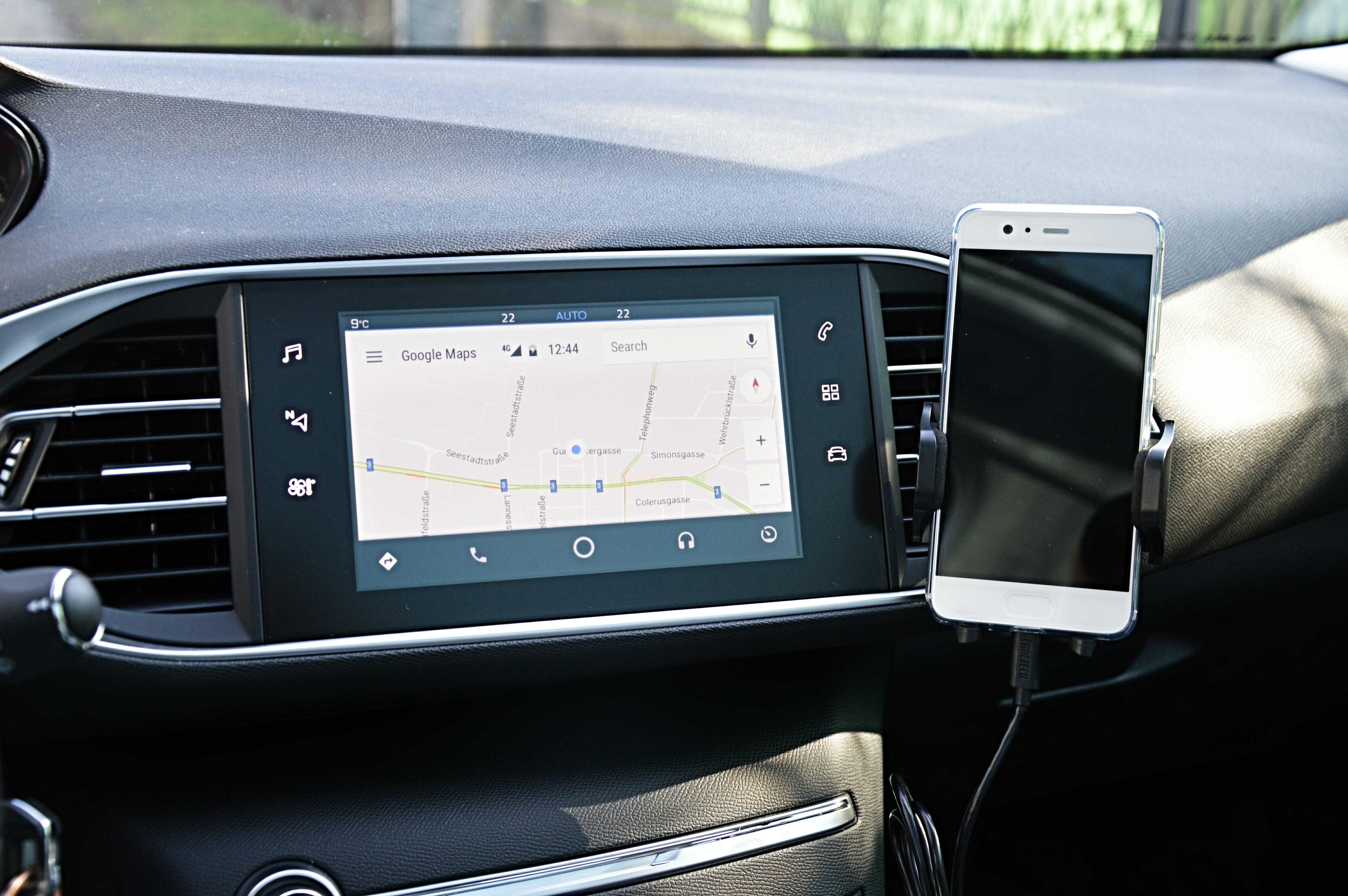 A dashboard display showing Android Auto alongside a connected phone.