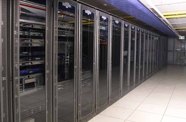 Rows of server racks with cables and equipment.