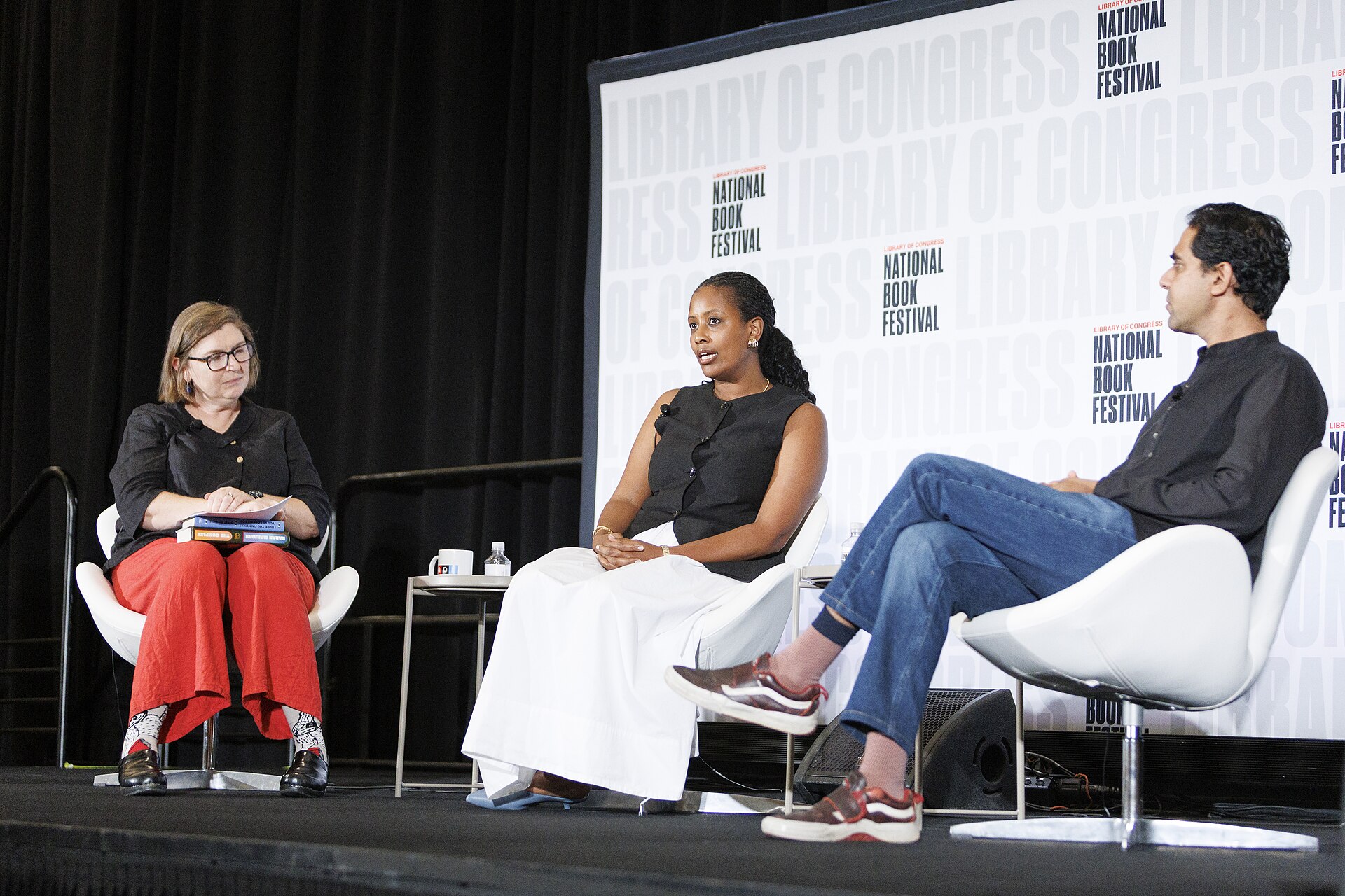 Three speakers seated on a stage with a National Book Festival backdrop.