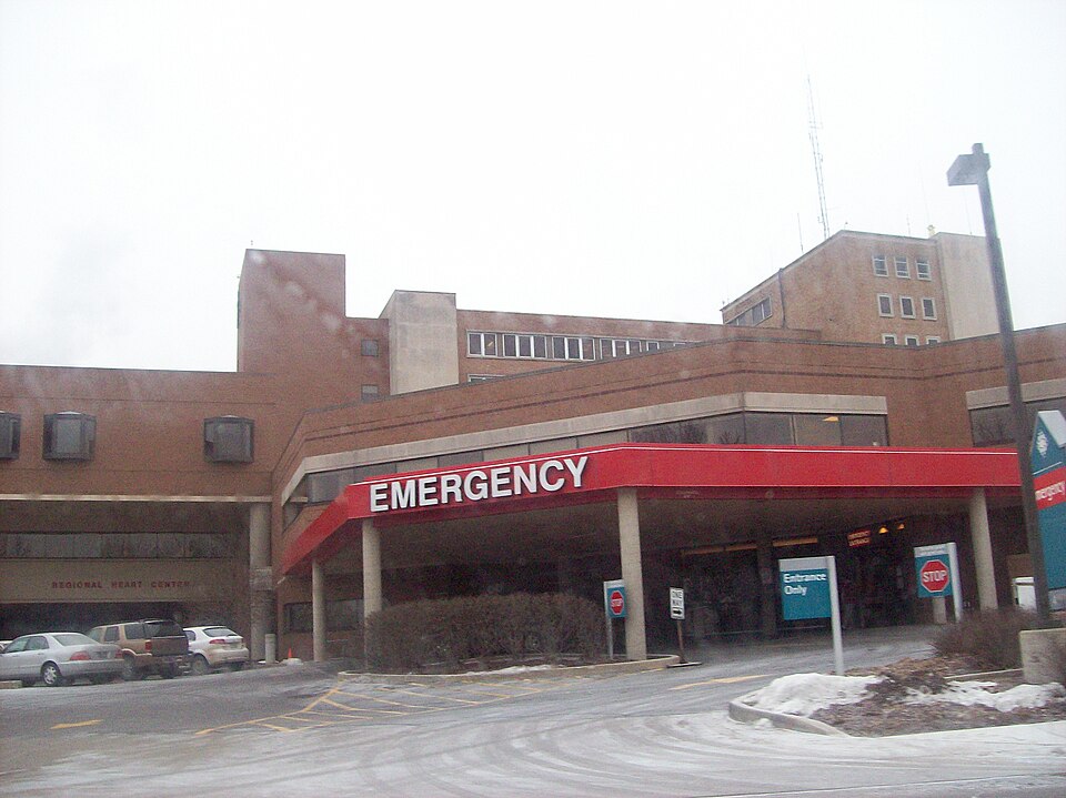 Hospital emergency entrance under a red canopy.