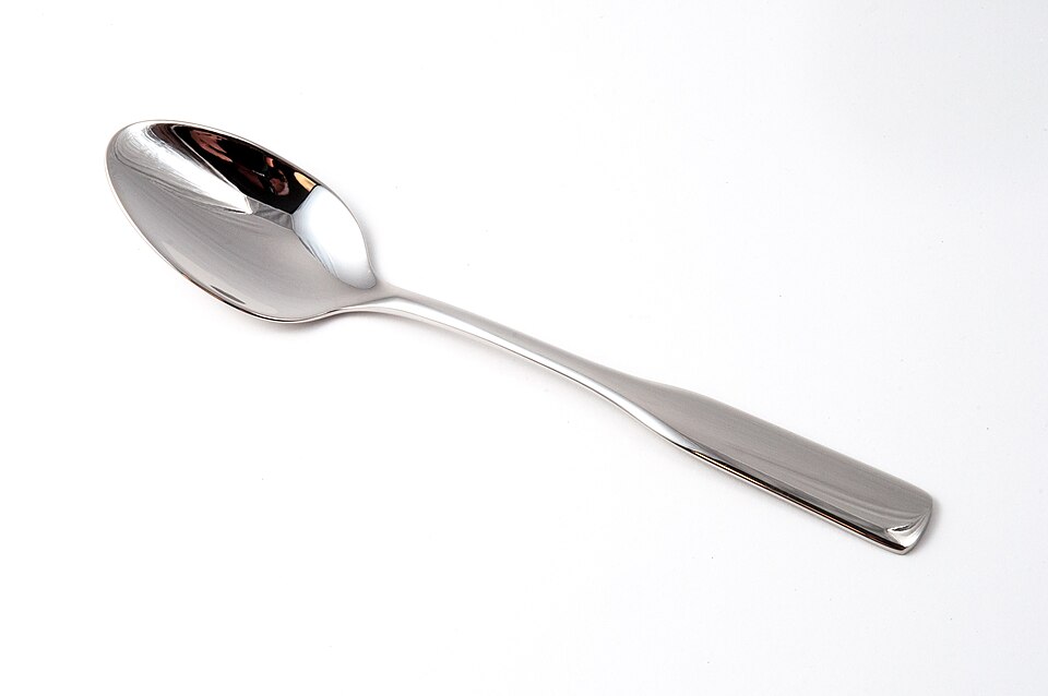 A metal teaspoon on a white background.