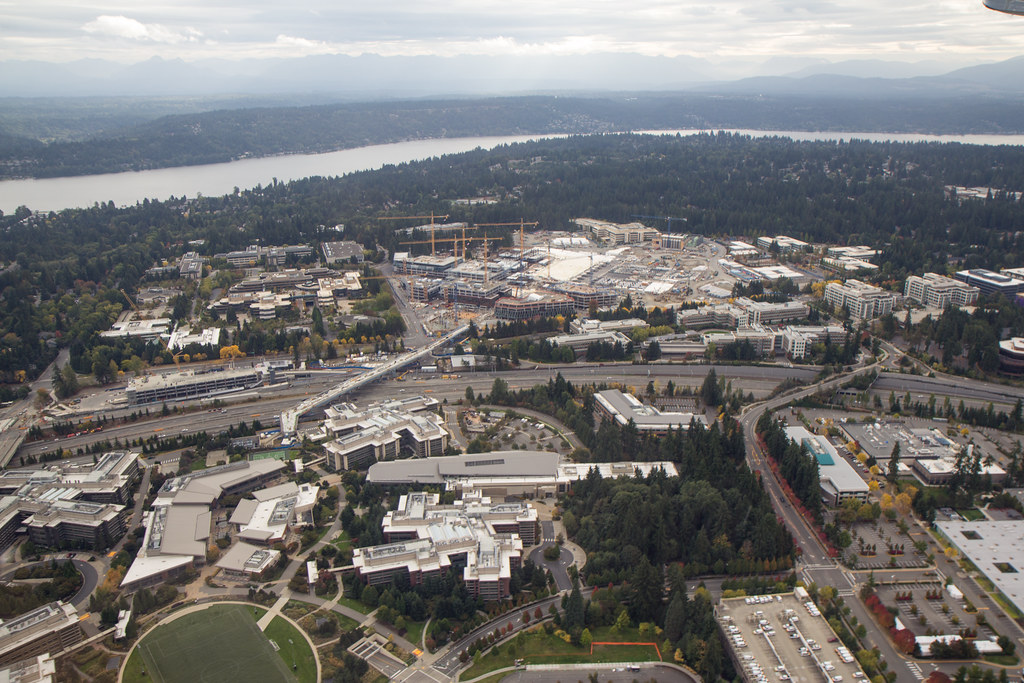 An aerial view of Microsoft buildings and construction, with a lake beyond.
