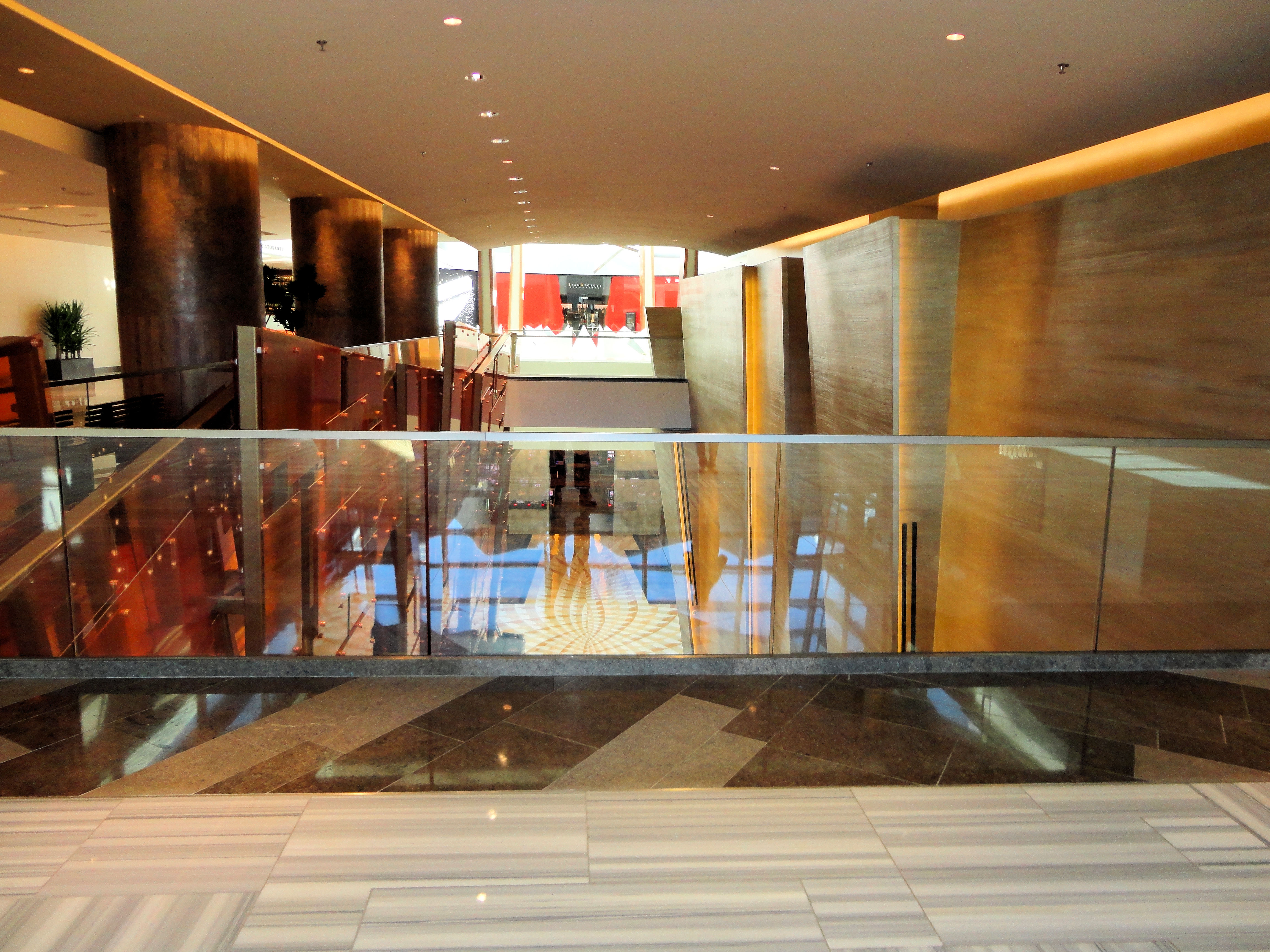 Glass railings and warm stone walls inside Aria Resort & Casino.