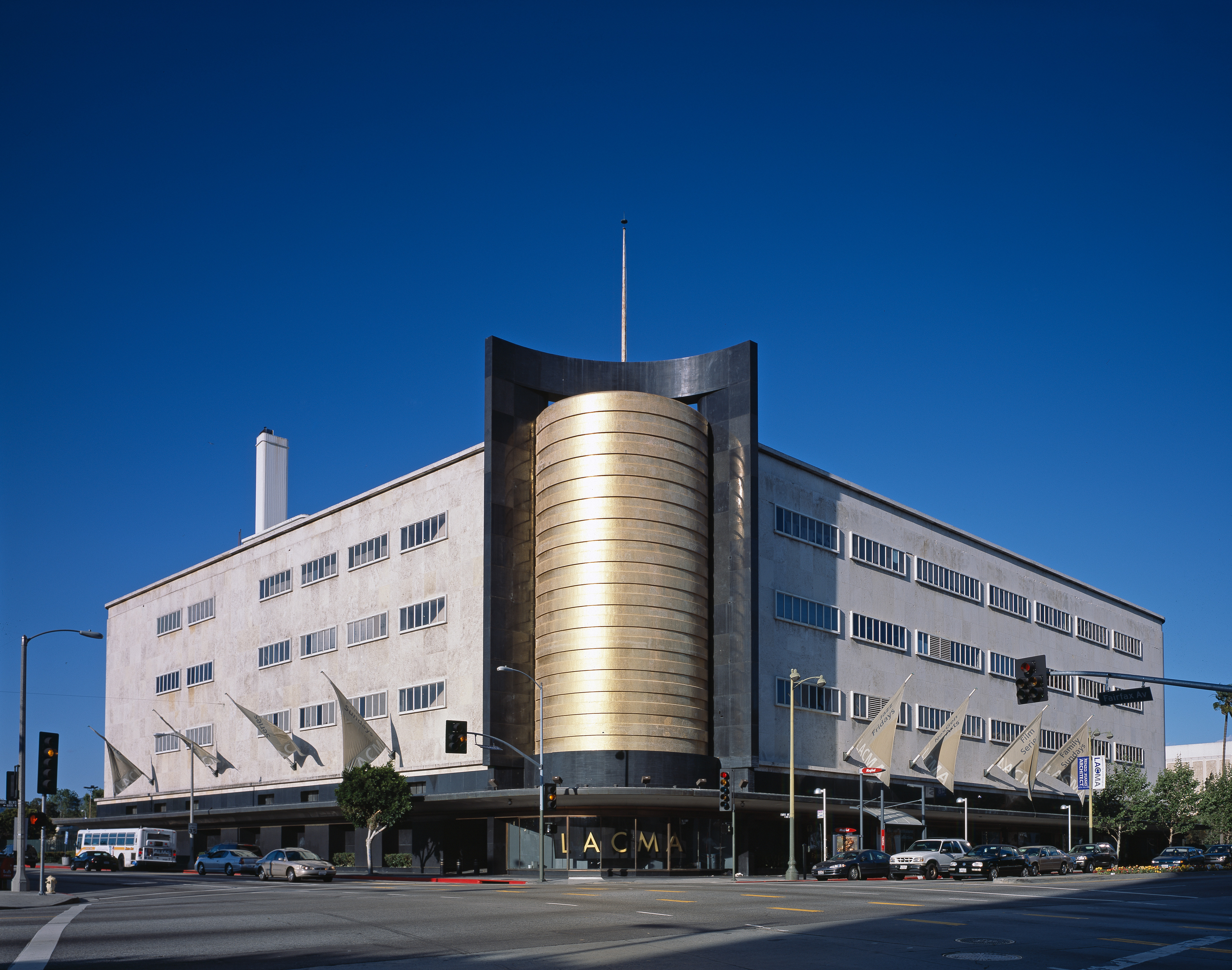 Art Deco building with a rounded gold-colored corner, photographed from across Wilshire Boulevard.