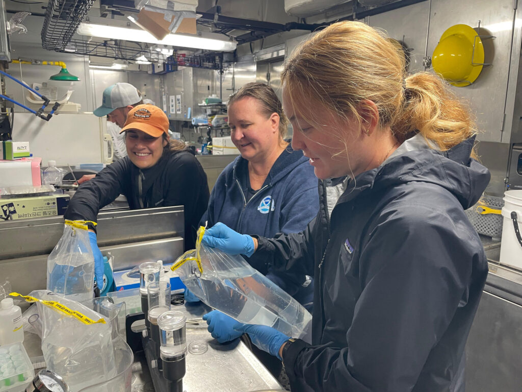Researchers filtering seawater samples.