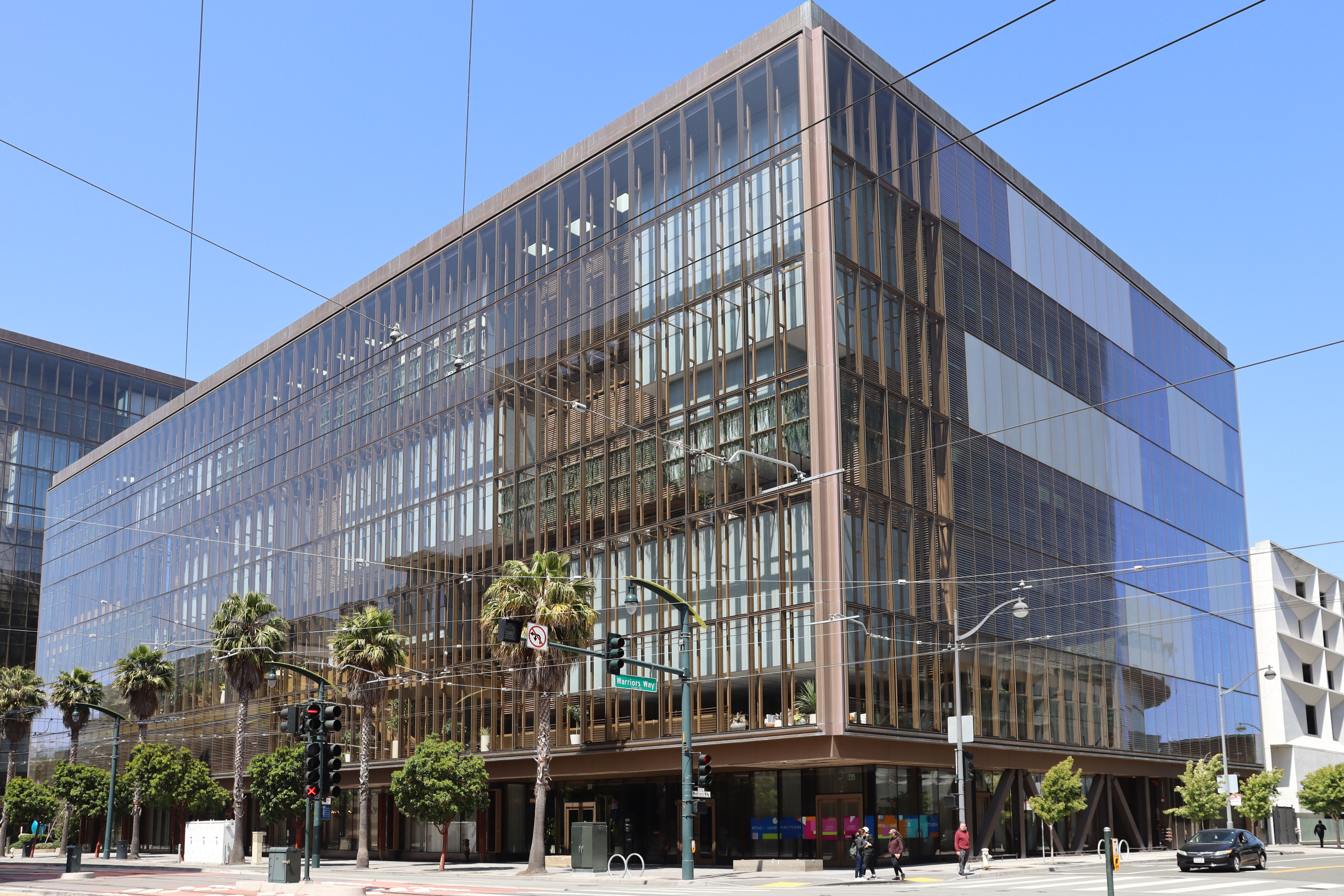 Glass-fronted office building at a San Francisco intersection.