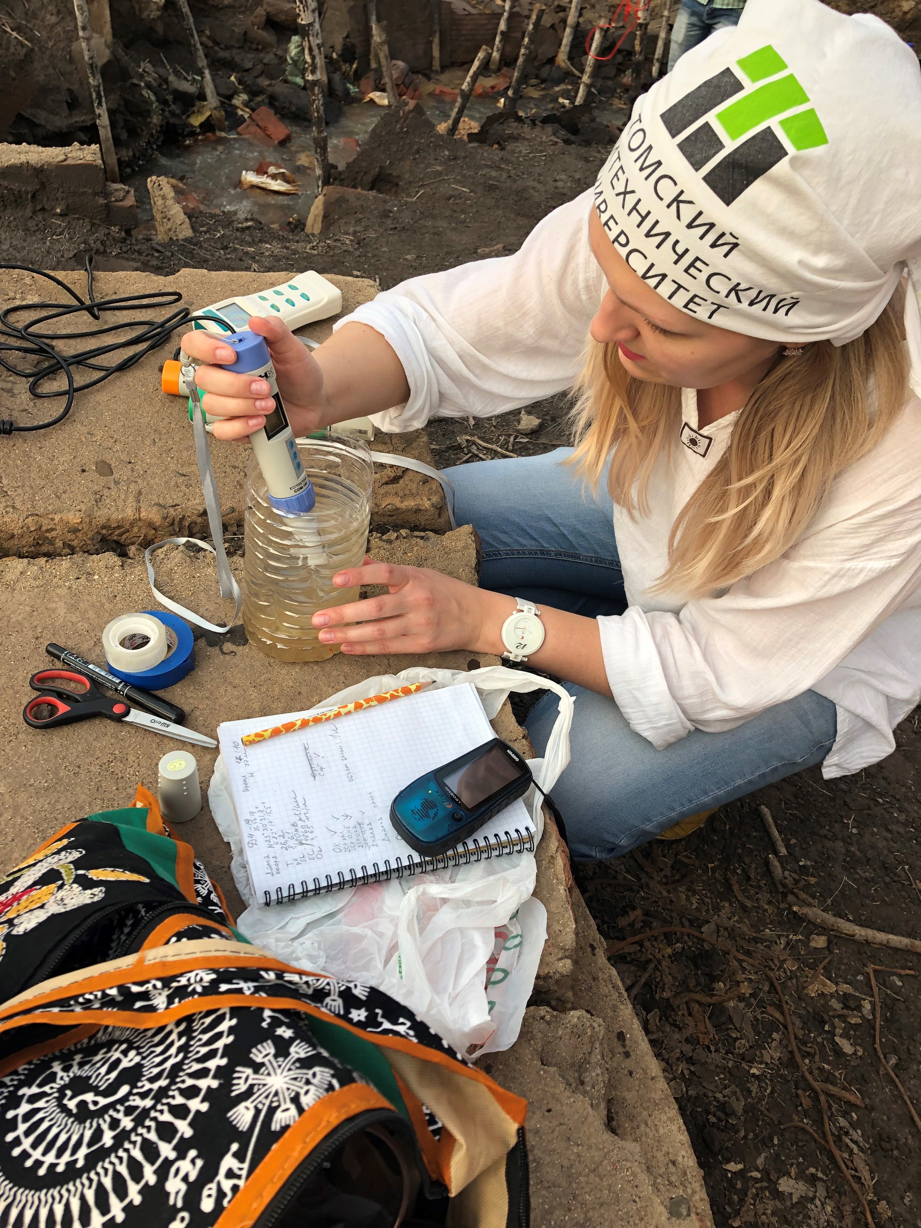 A field worker holds a probe in a wastewater container.