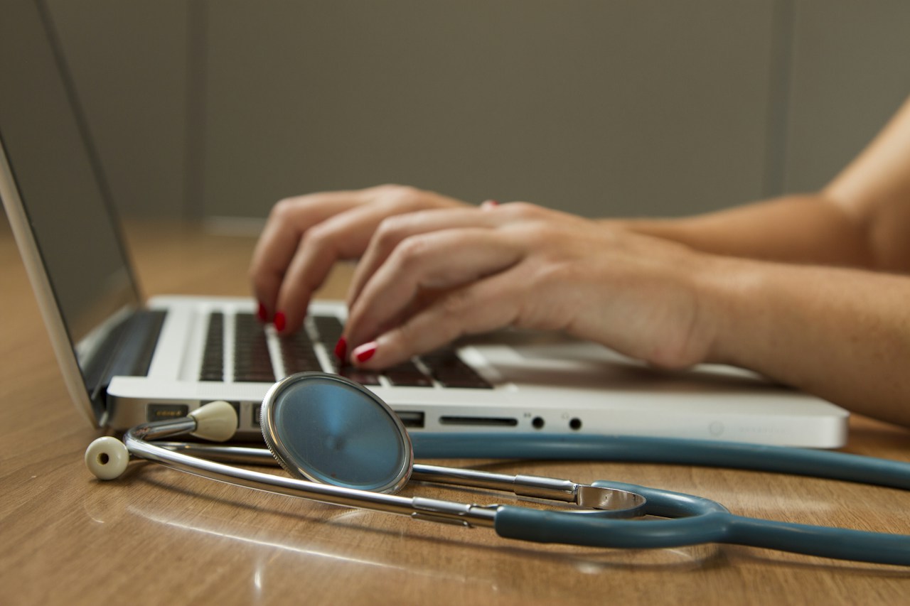 Stethoscope beside laptop.