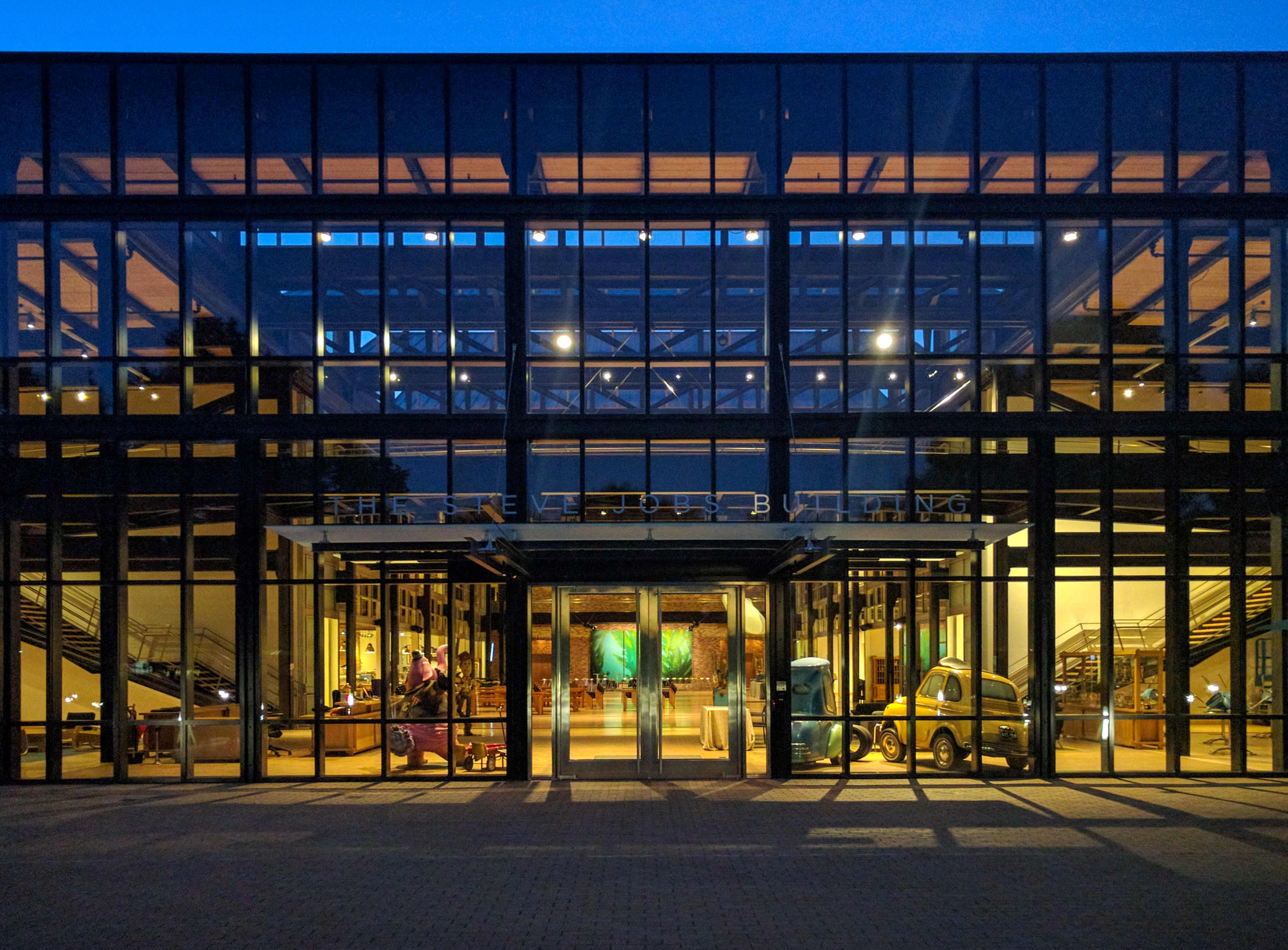 The illuminated Steve Jobs Building at Pixar at dusk