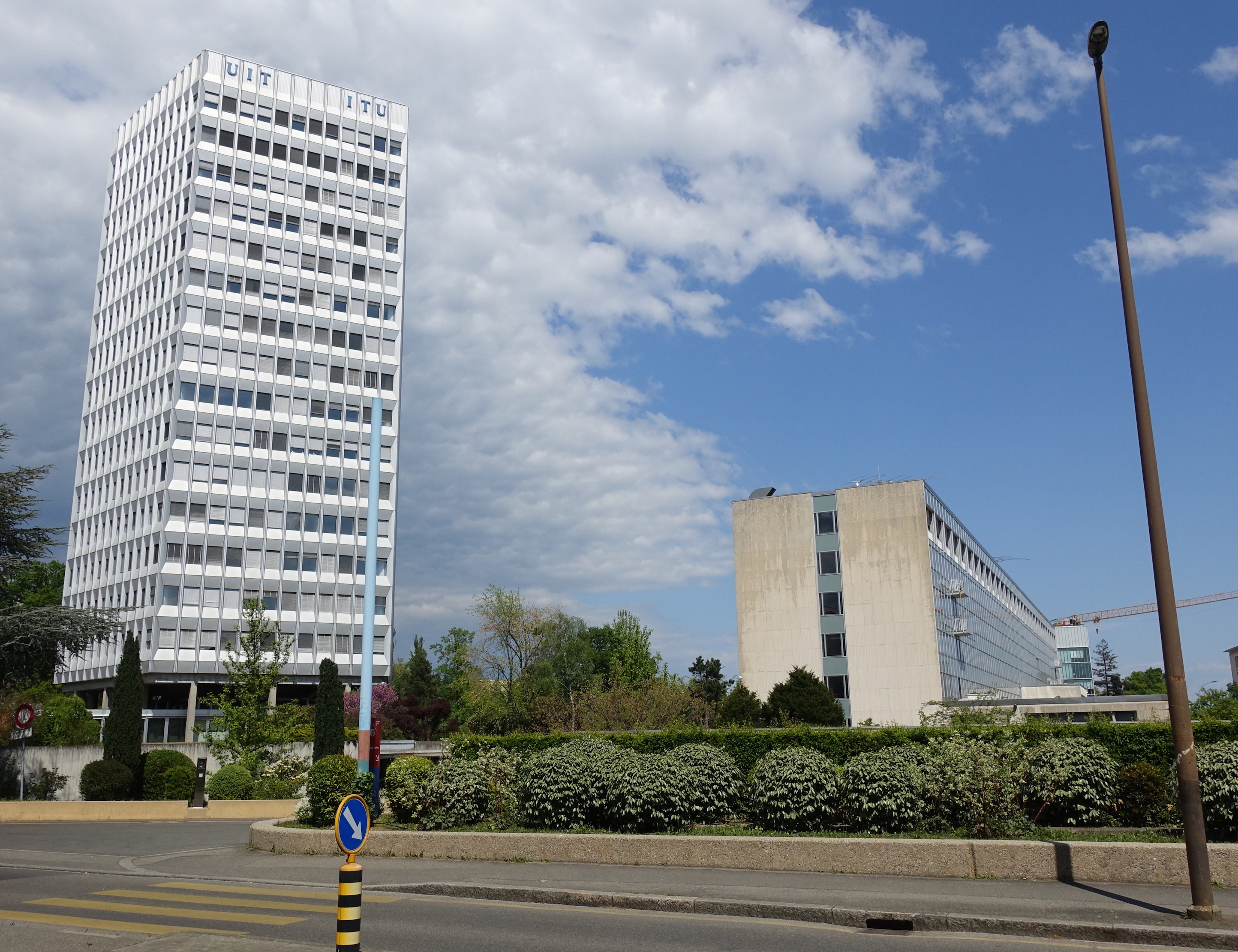 ITU’s tower and a lower headquarters building beside a Geneva street.