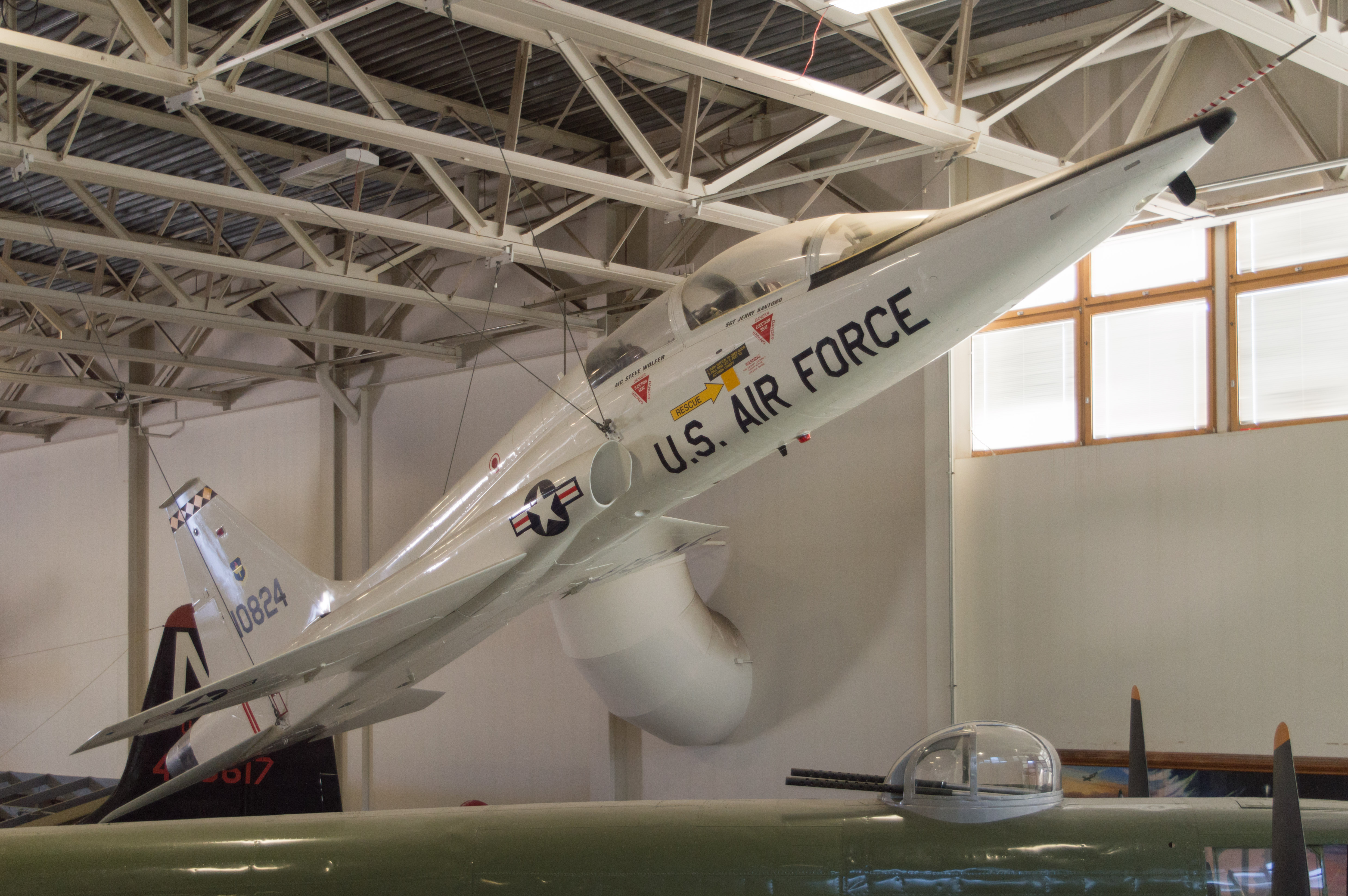 Historic aircraft are displayed inside a museum hangar.