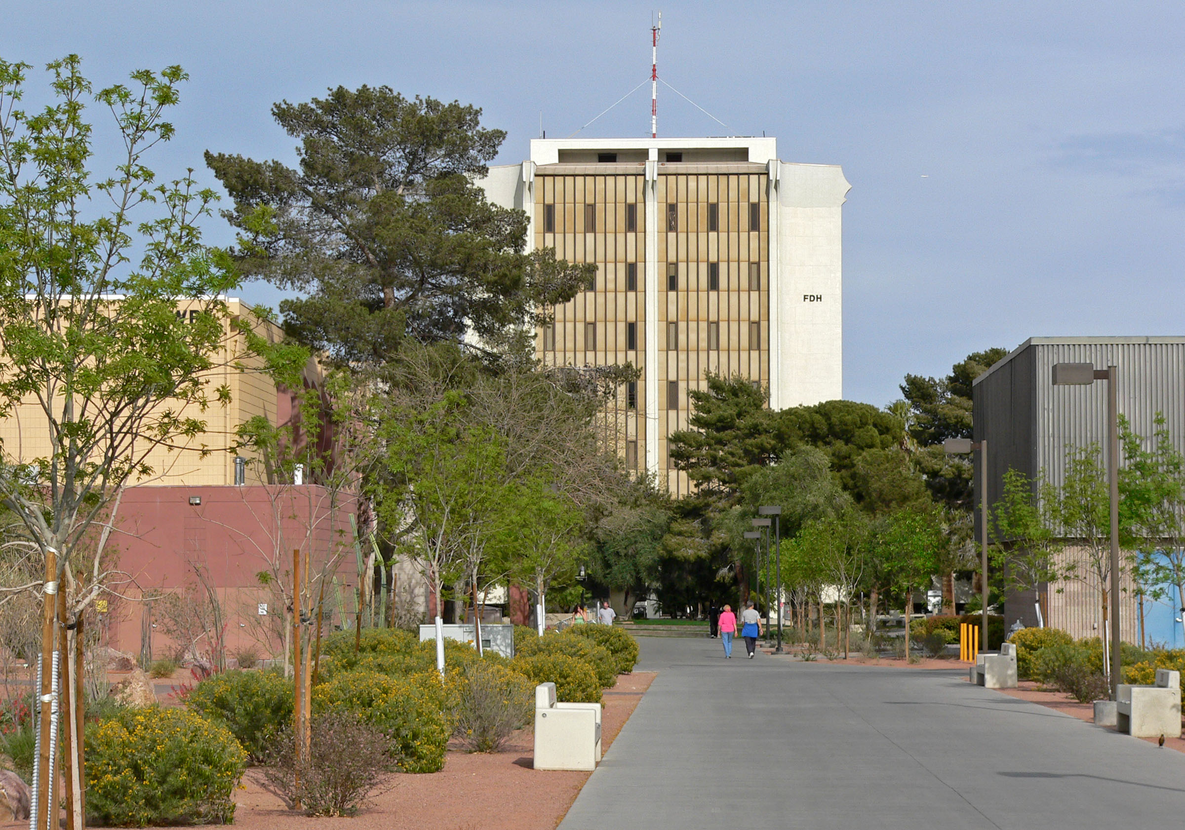A campus walkway, trees and the Flora Dungan Humanities building at UNLV.
