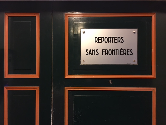 Reporters Sans Frontières sign on a dark paneled door.