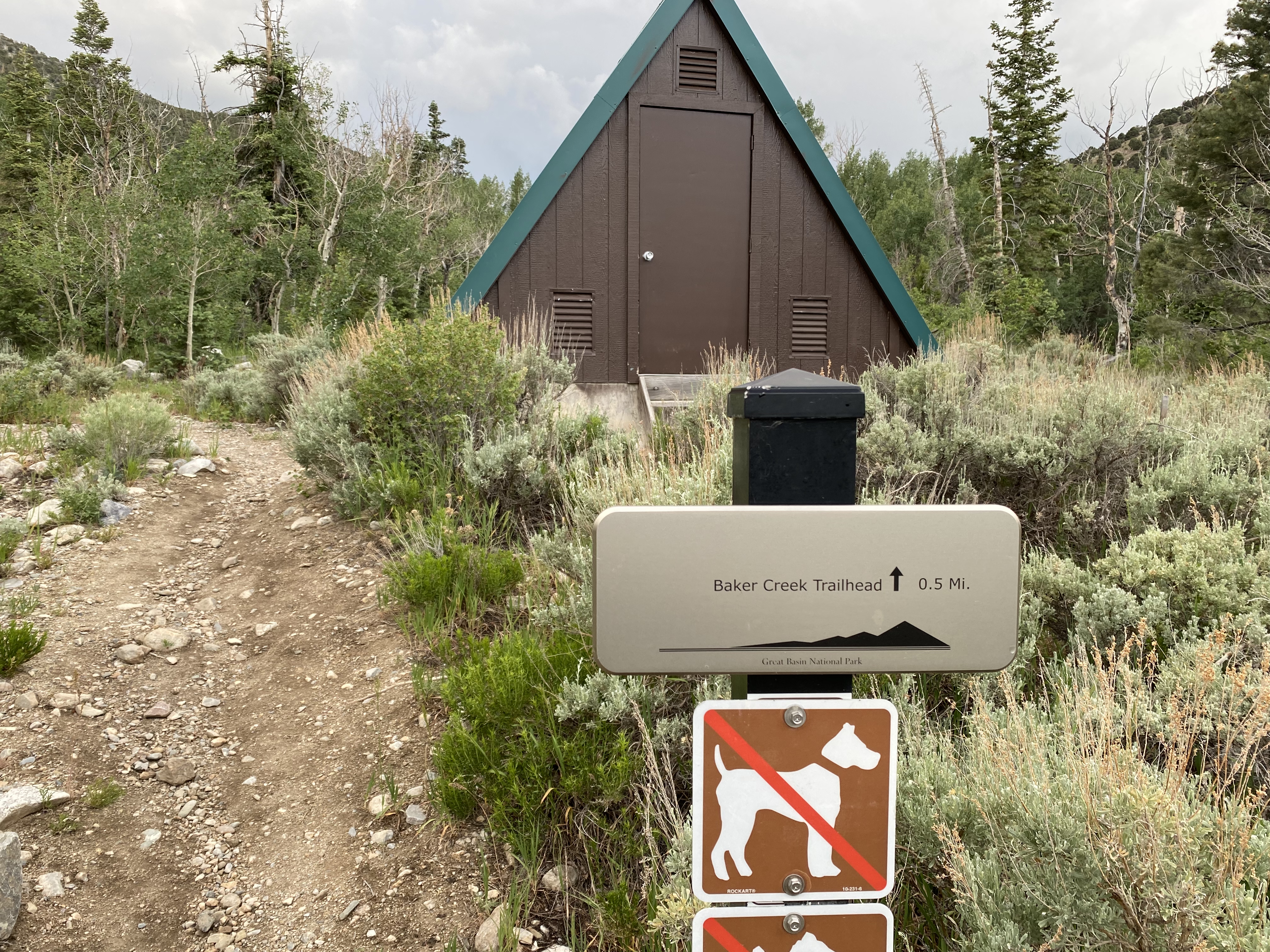 A campground building and Baker Creek Trailhead sign.