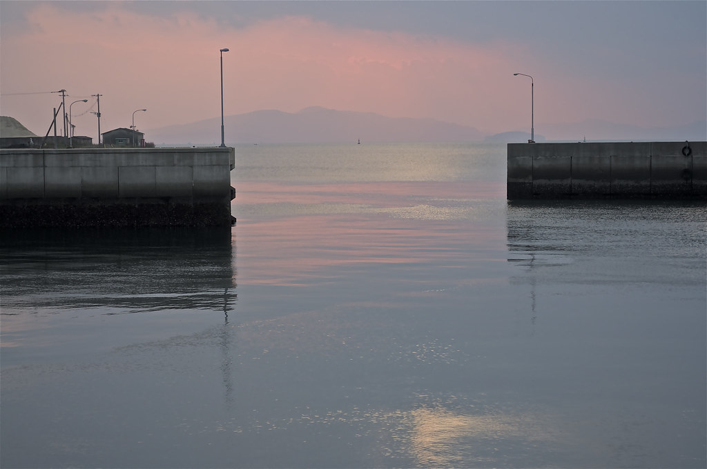 Harbour walls frame calm water at Minamata Bay.