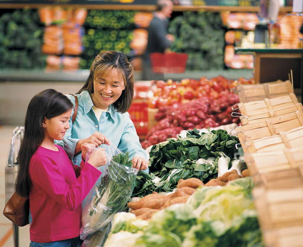 File photo (2013): an adult and child choose vegetables in a supermarket produce aisle.