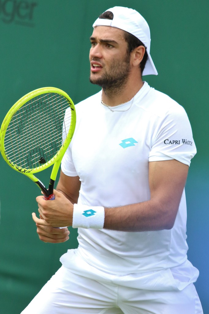 Matteo Berrettini prepares with his racket on court.