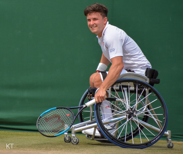 File photo (2018): Gordon Reid holds a racket beside his sports wheelchair on grass.