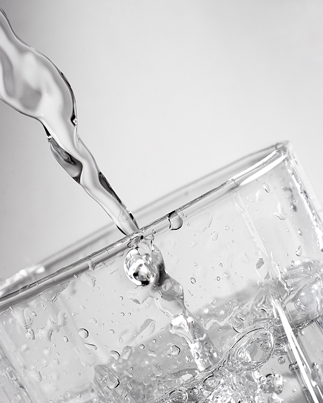 Water pouring into a clear glass.
