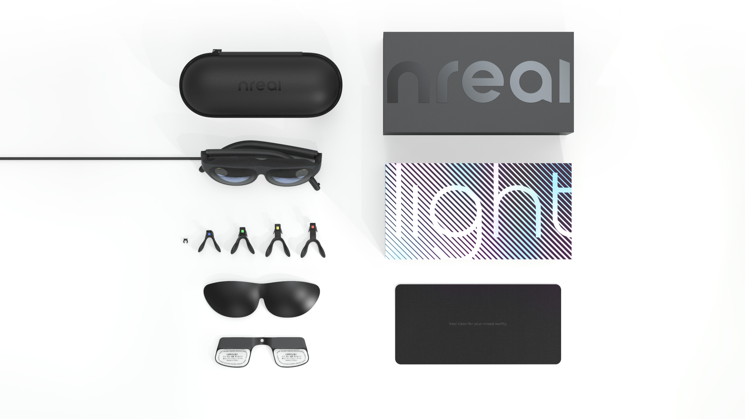 Nreal Light glasses, case, packaging, nose pads and lens accessories arranged on a white surface.