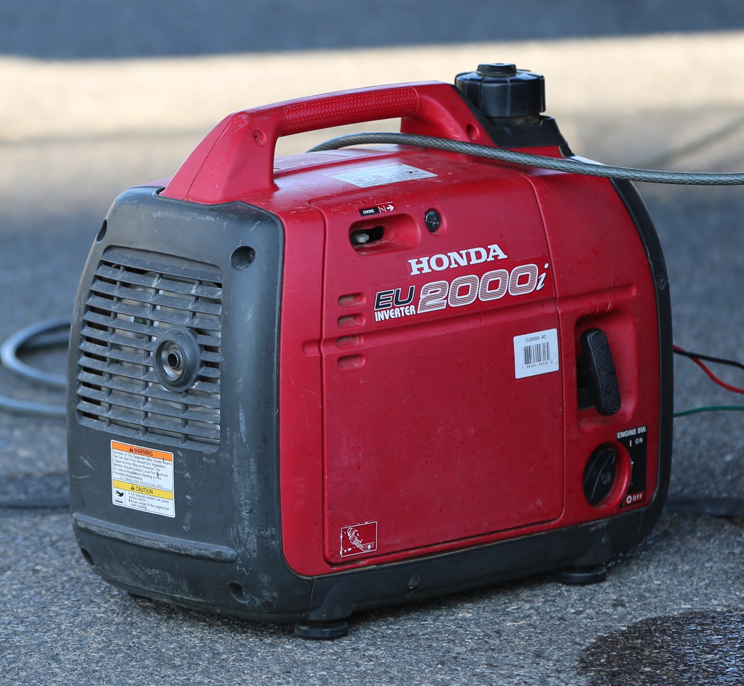A red portable generator photographed outdoors.