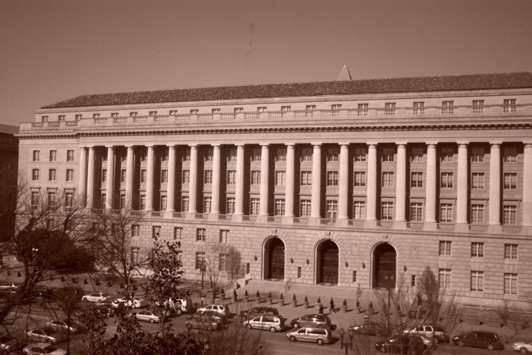 Columned IRS headquarters building with cars along the street.
