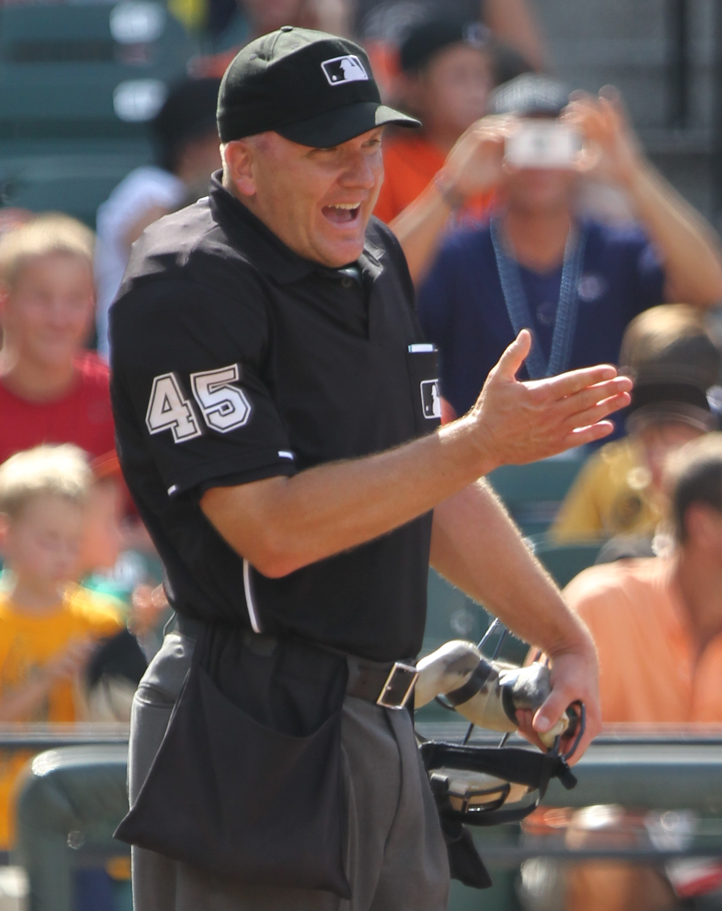 An umpire holds his mask beside a catcher.