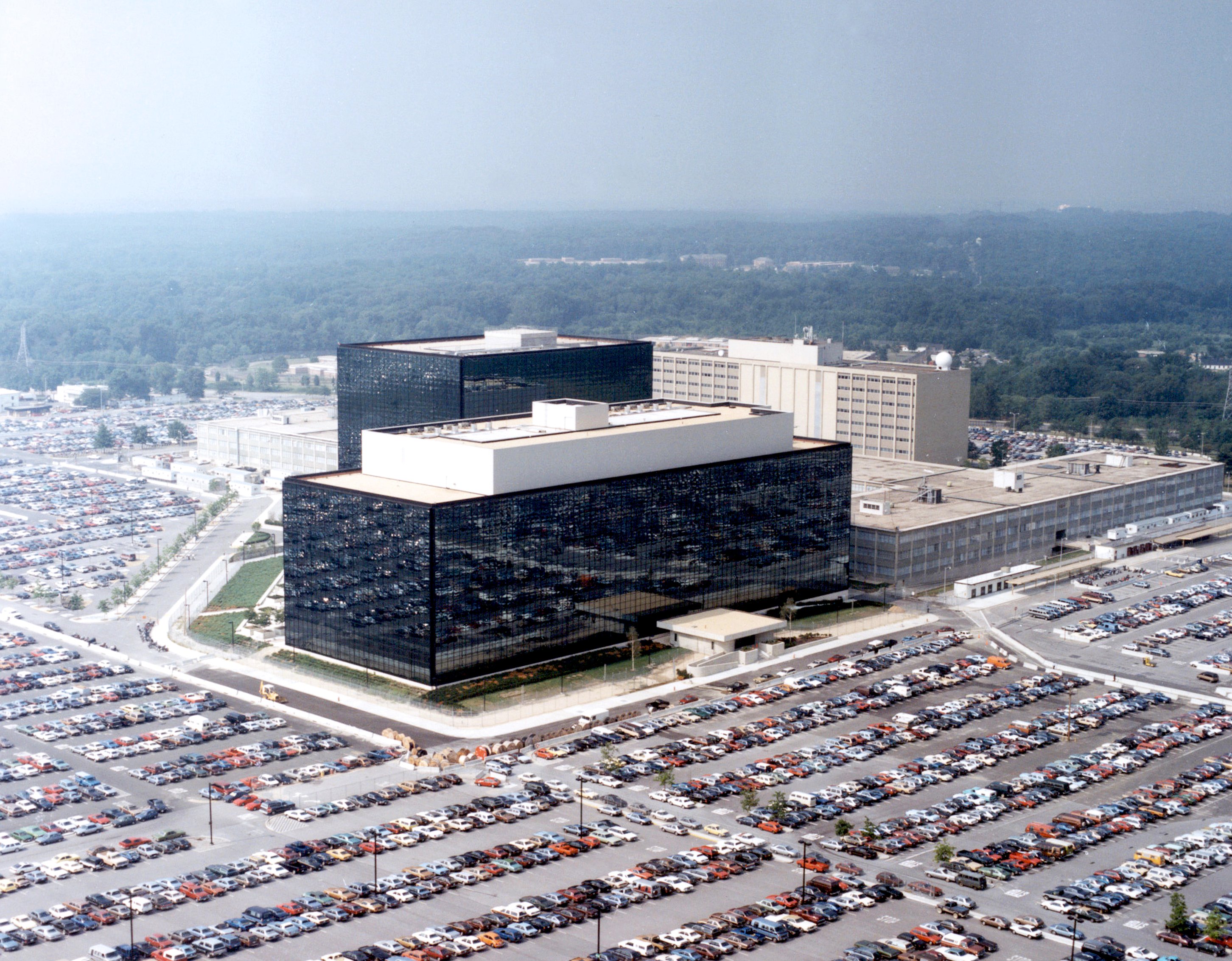 Dark-glass office buildings surrounded by parking areas.