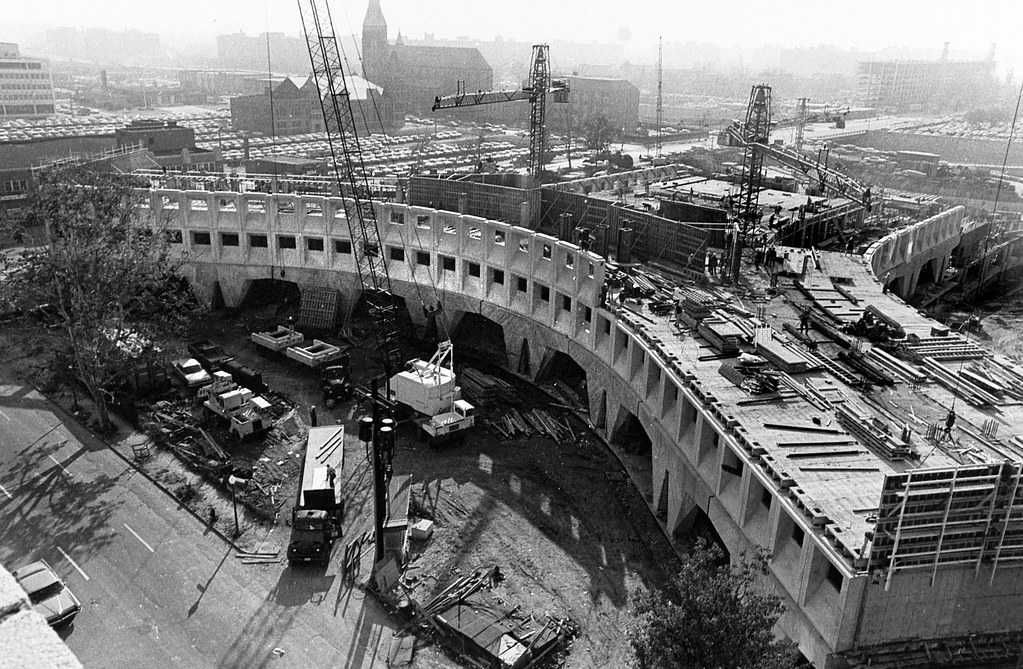 Black-and-white view of HUD headquarters under construction with cranes.